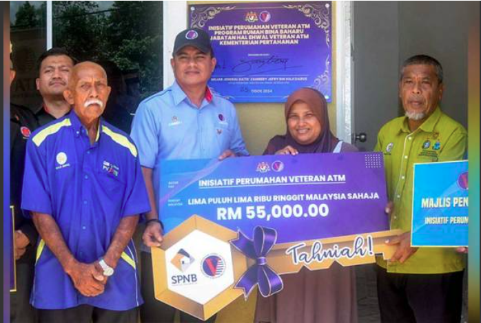 Zambery (dua, kiri) bersama penerima bantuan rumah bina baharu JHEV, Yuslina Yusof, (dua, kanan) di Kampung Bukit Cina, dekat Pasir Akar, Hulu Besut pada Ahad.